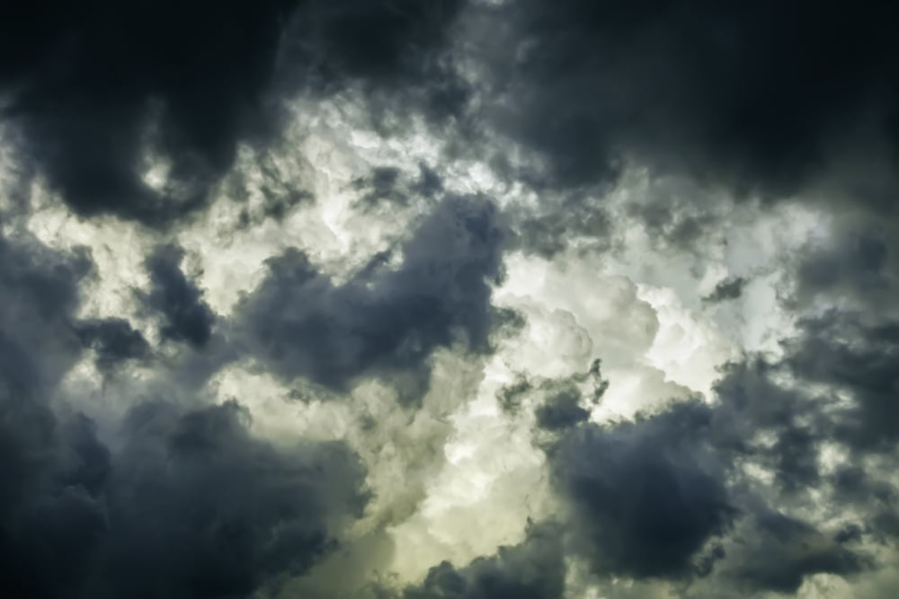Storm clouds in summer Ragged wind-driven dark clouds move in quickly to obscure large white billows before sunset, for meteorological themes of instability and rapid change Storm clouds in summer Ragged wind-driven dark clouds move in quickly to obscure large white billows before sunset, for meteorological themes of instability and rapid change