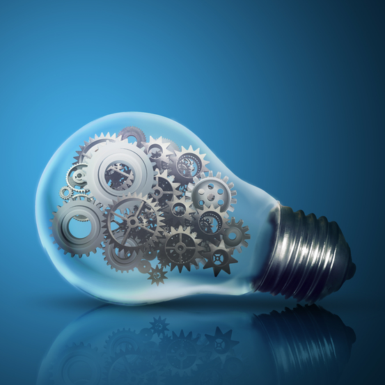 Close up of light bulb with gear mechanism inside isolated on dark blue background-crop