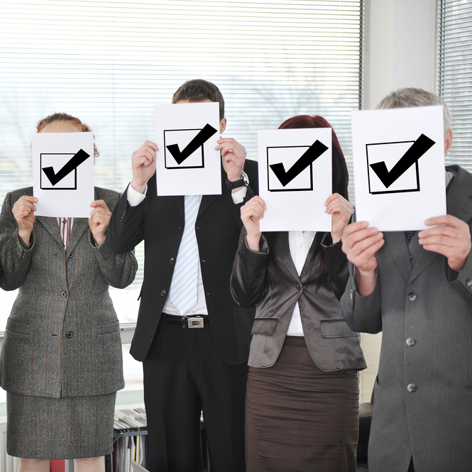 Successful team holding check mark vote sign-crop